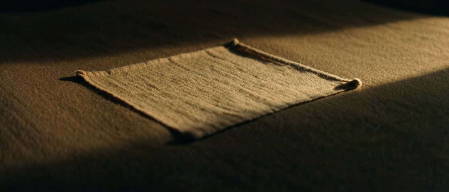 a sheet of silk pinned taut at its corners, the weave pulled dead straight