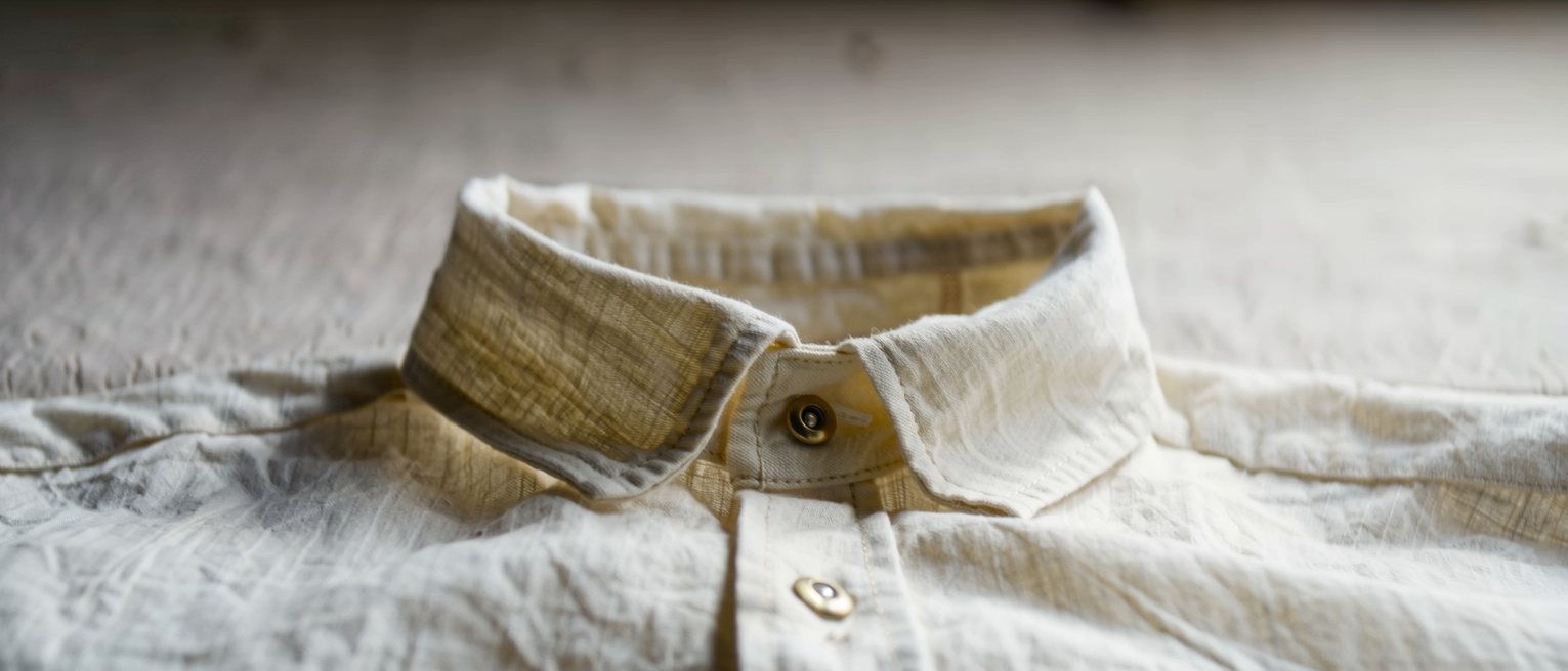 a starched linen collar released from its stud and gone soft at the fold