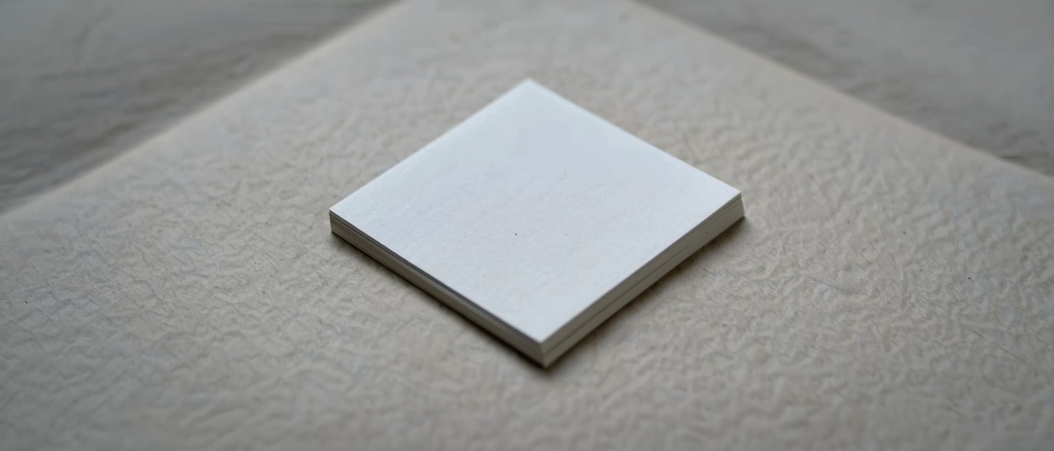 a squared stack of blank white cards on a table, the edges perfectly aligned