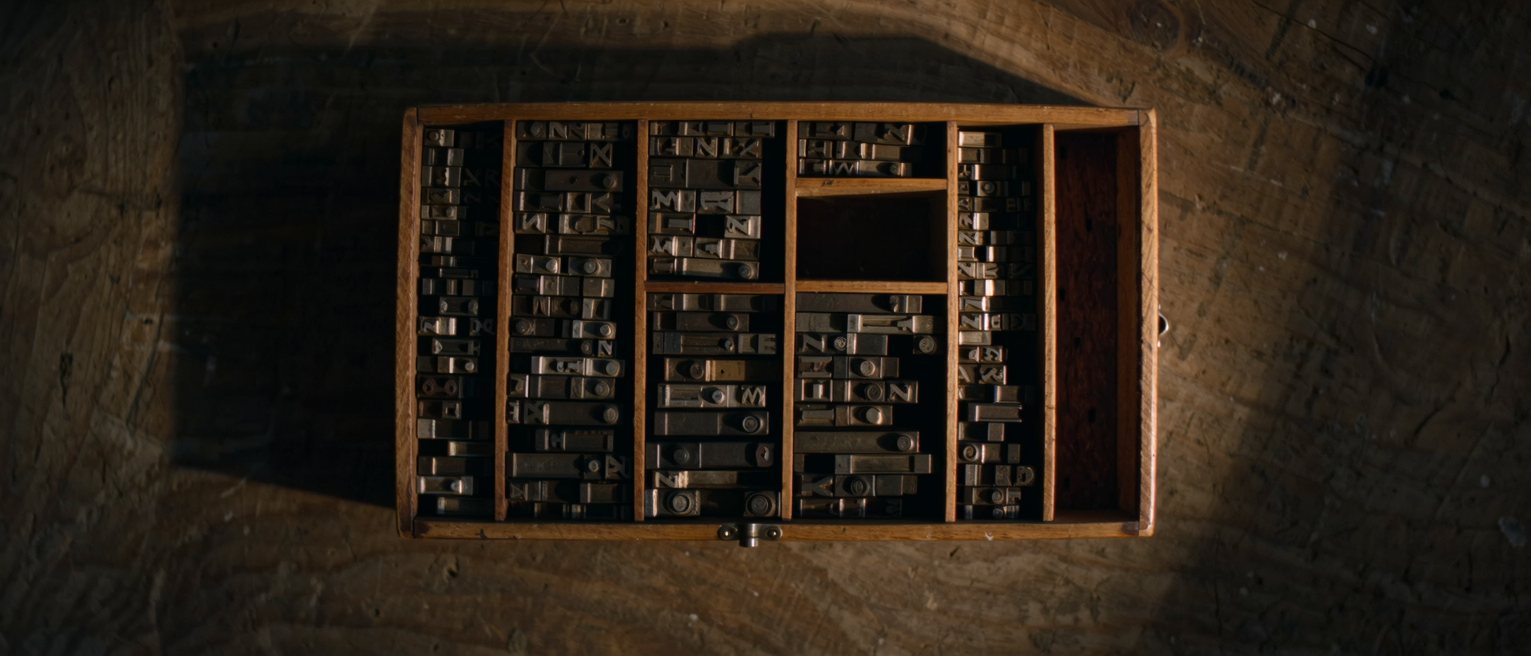 a printer's wooden type case, every compartment packed to the brim with metal type but one standing empty