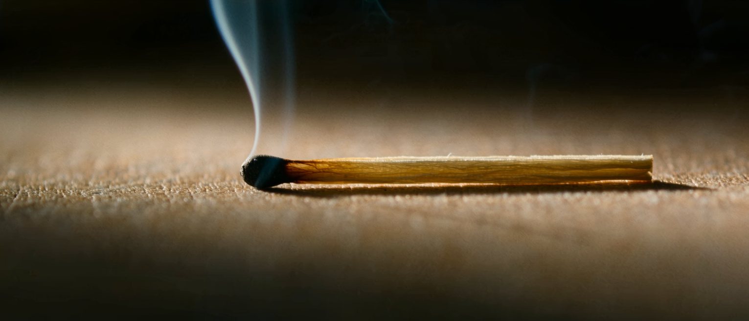 a struck match still smoking, laid down whole and unburned past the head