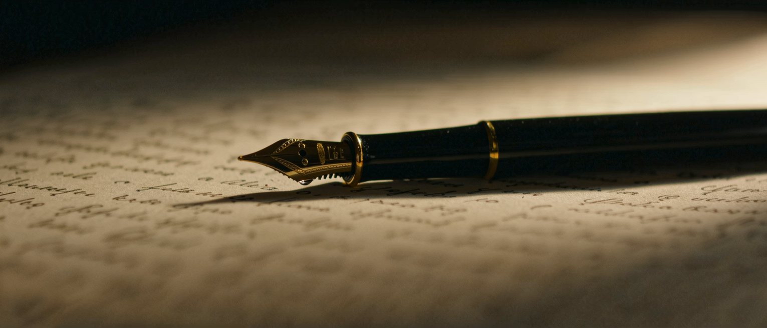 a fountain pen set down beside a written page, the nib still wet