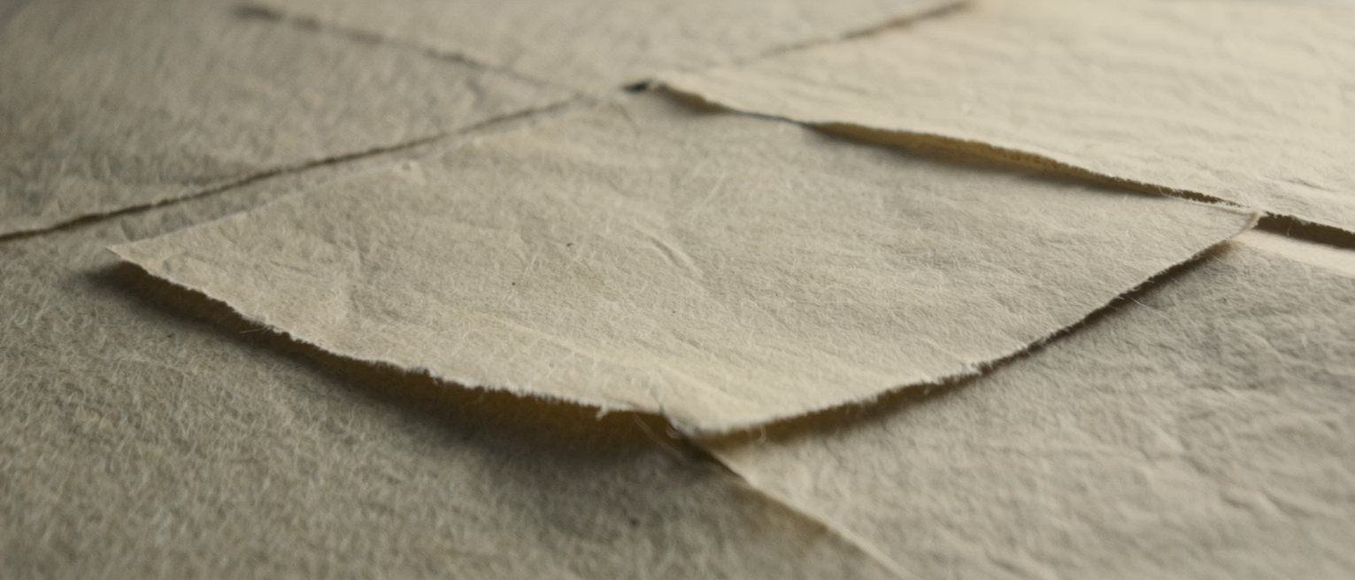 a sheet of handmade paper with a wide uncut margin on every side, the deckle edge intact