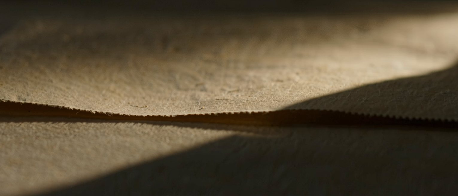 a sheet of handmade paper with a wide uncut margin on every side, the deckle edge intact