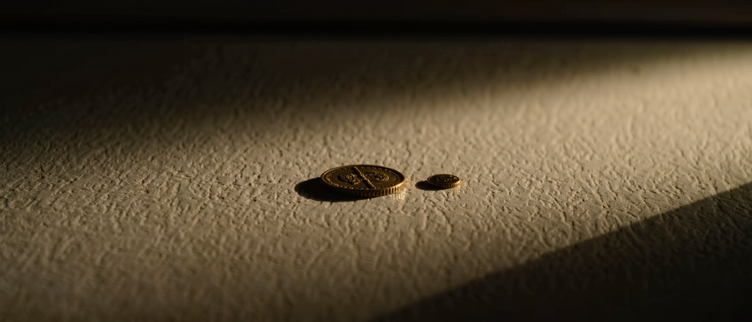 two separate brass tokens of different sizes lying on a counter