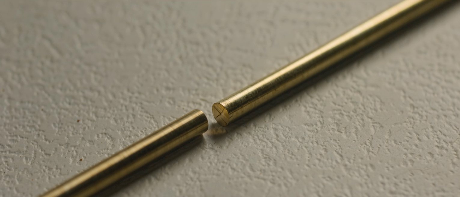 two lengths of the same brass rod cut and laid end to end without touching, a hair's gap left between them