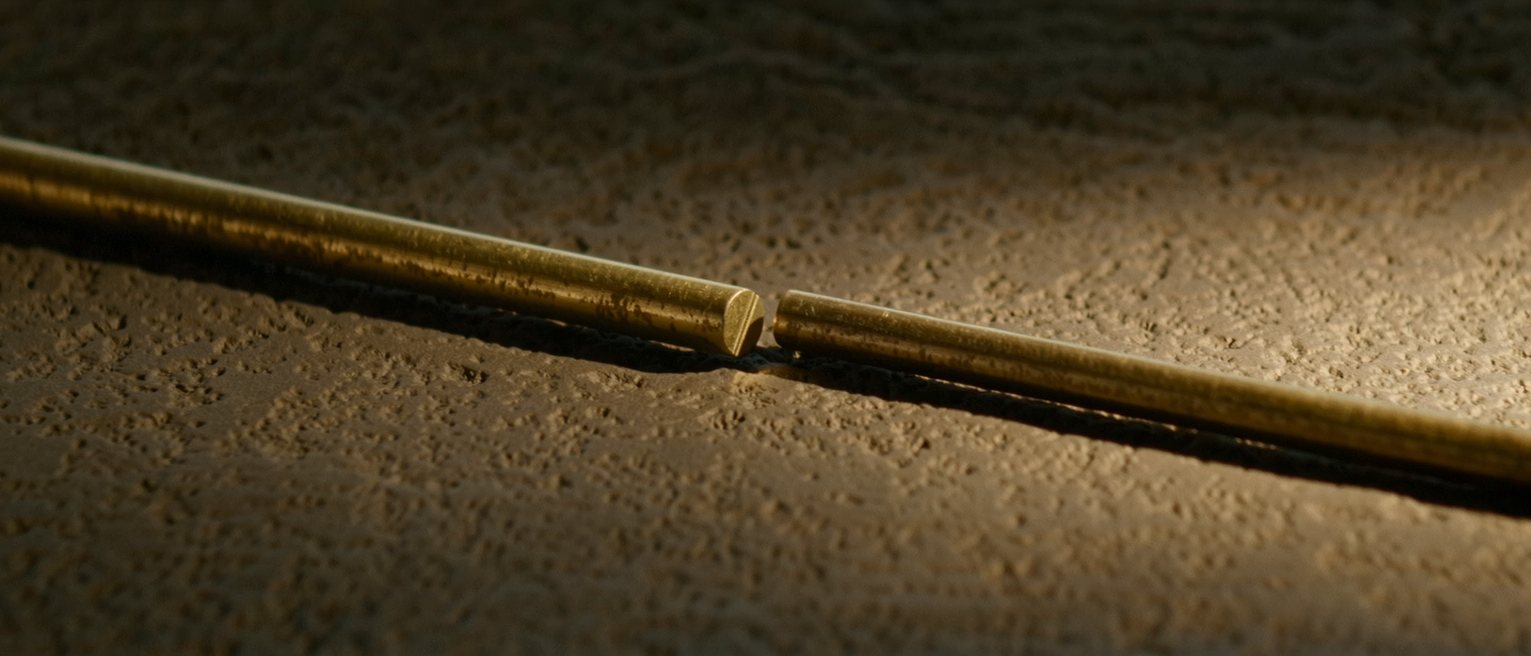 two lengths of the same brass rod cut and laid end to end without touching, a hair's gap left between them
