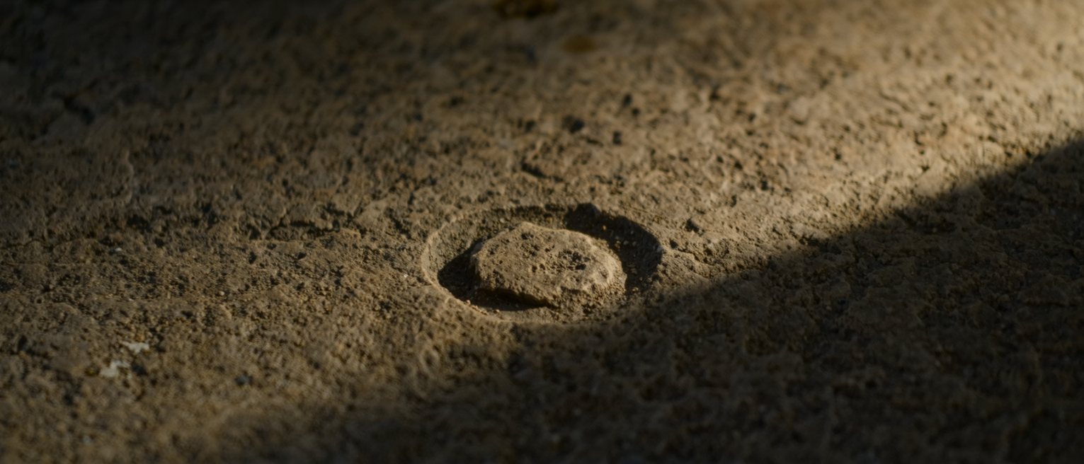 a tidal mark left across a harbour wall, the stone darker below the line