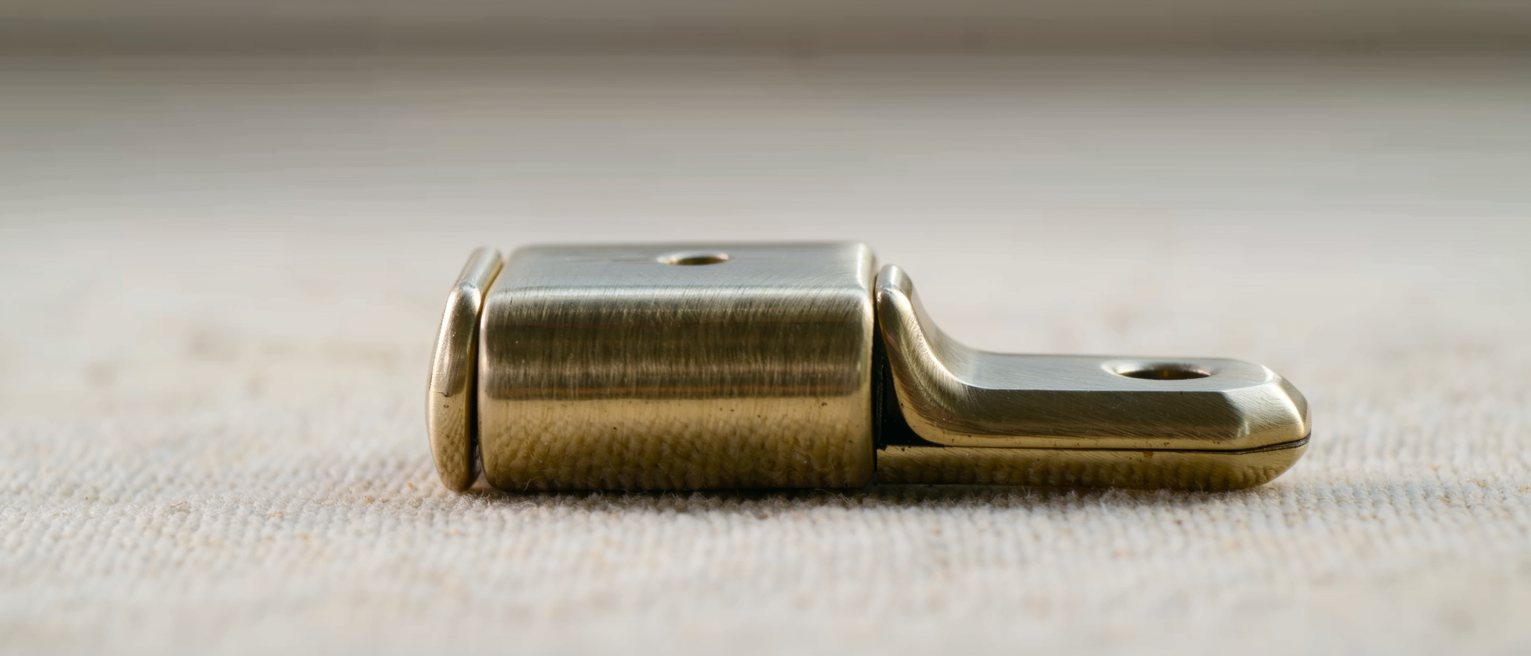 a brass window stay resting on its second peg