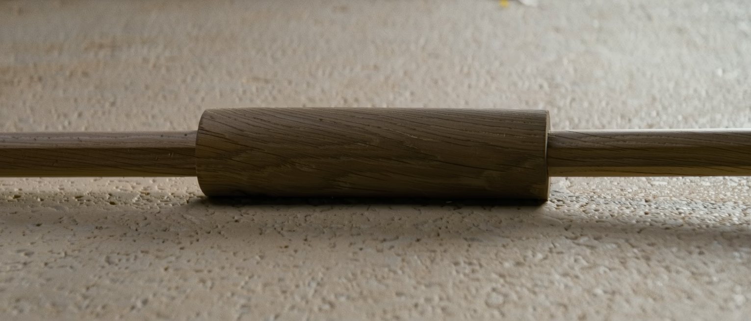 the top rail of a wooden garden gate, its ends tenoned into the stiles and the rail planed smooth along its length