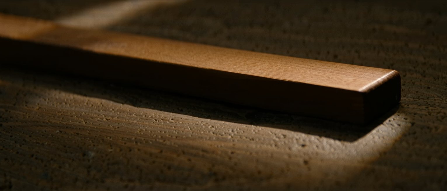 the top rail of a wooden garden gate, its ends tenoned into the stiles and the rail planed smooth along its length