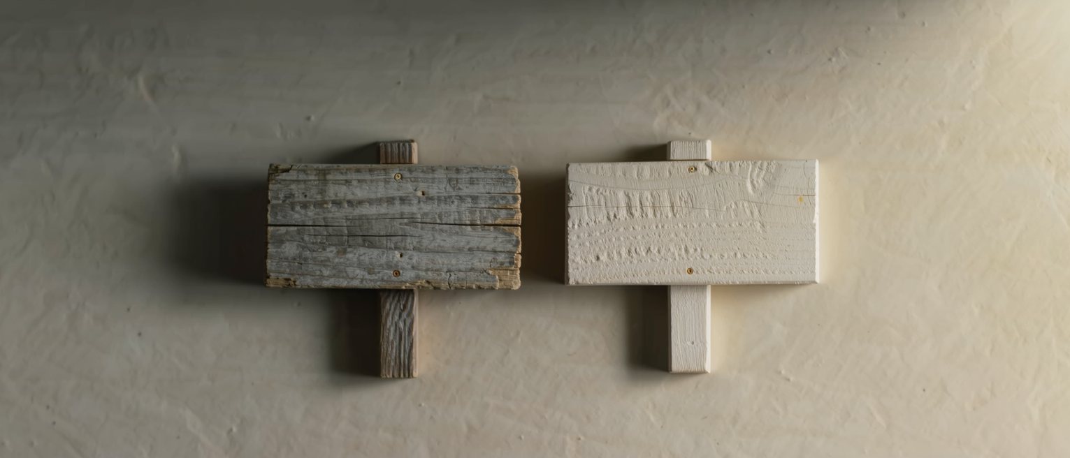 two wooden signboards planed from the same plank, one weathered grey and the other still pale