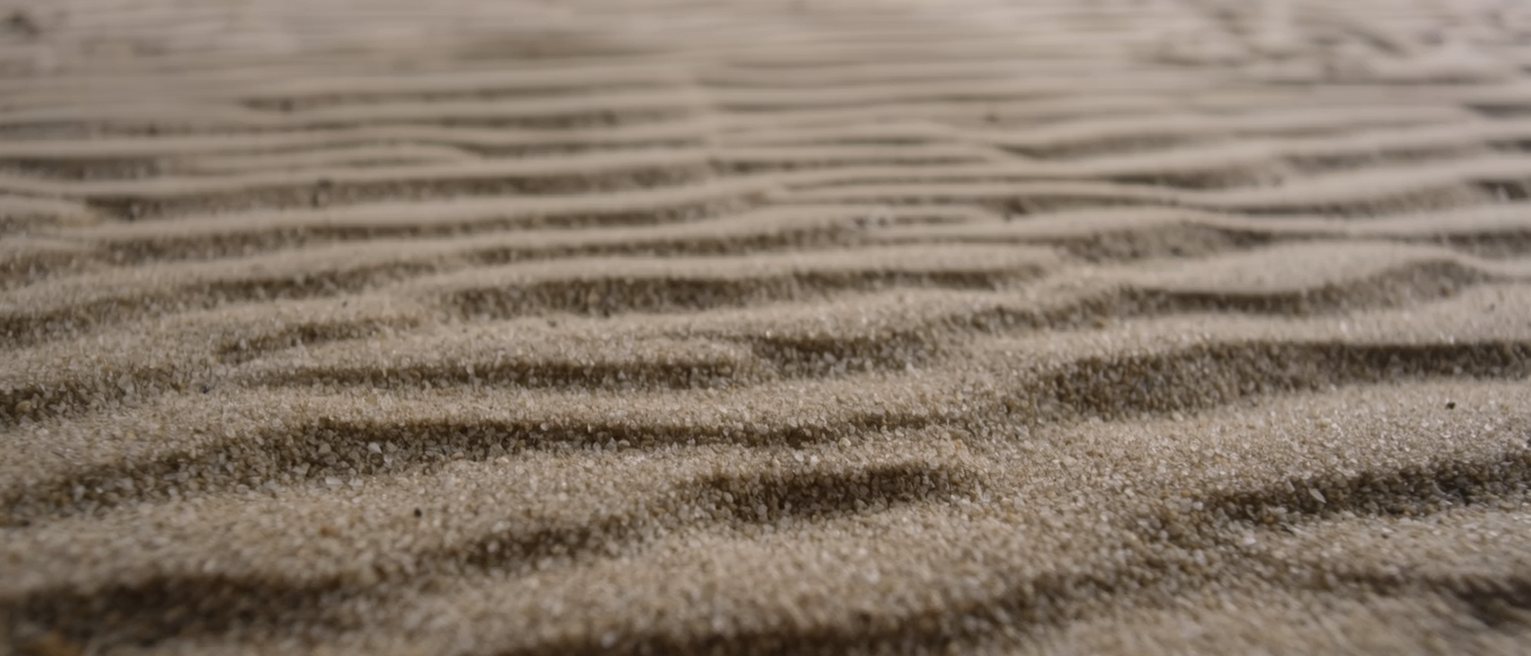 a bed of fine dry sand raked flat and unmarked
