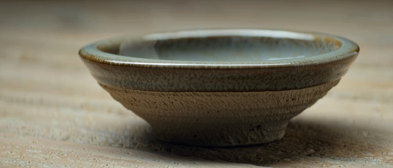 a stoneware pot glazed a second time over an older glaze, the two meeting at the rim