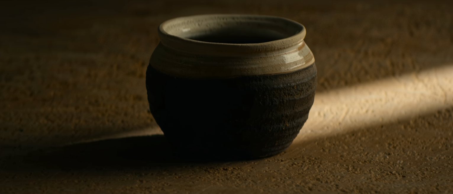a stoneware pot glazed a second time over an older glaze, the two meeting at the rim