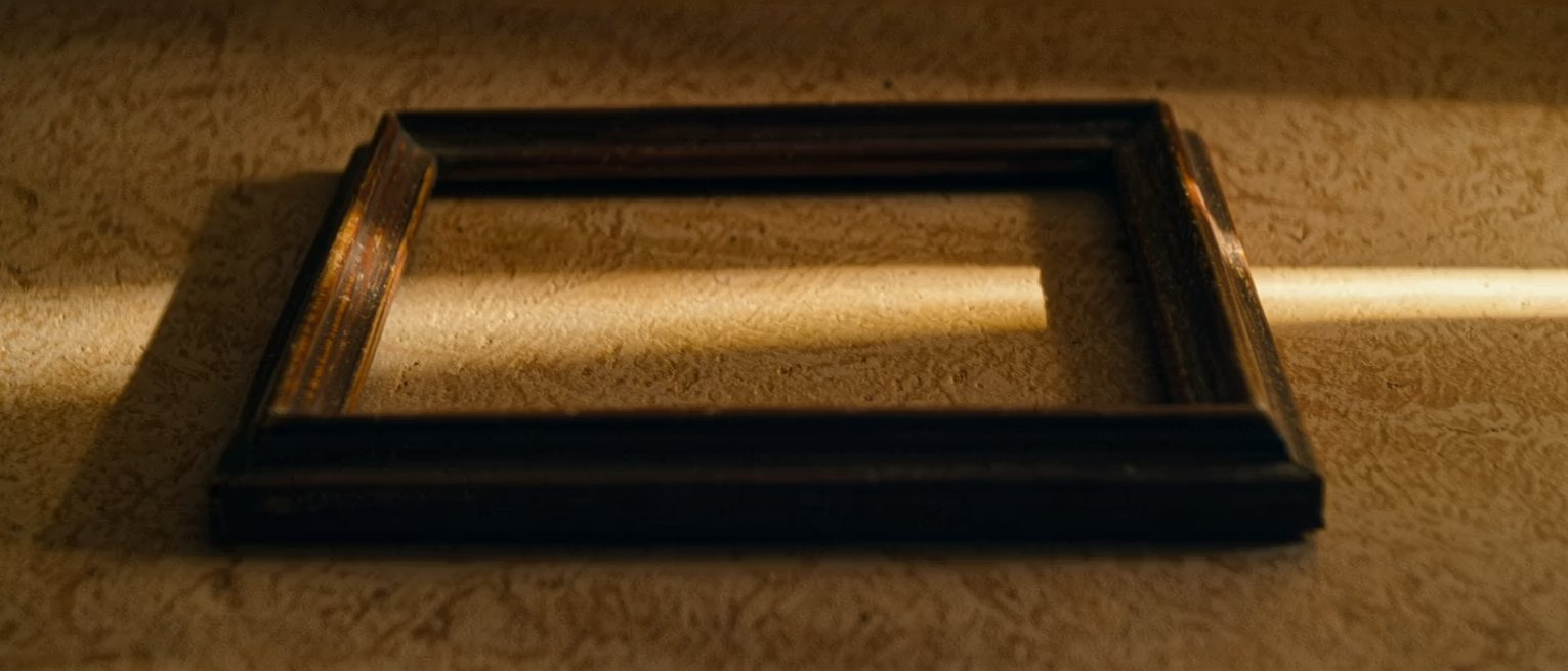 an empty picture frame of dark wood lying flat, nothing mounted in it
