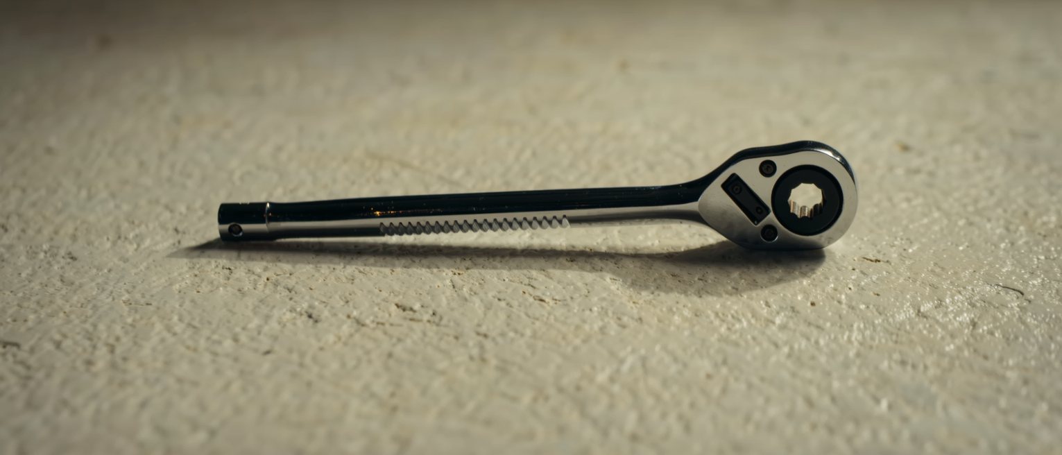 a steel ratchet handle with its pawl set and the teeth engaged