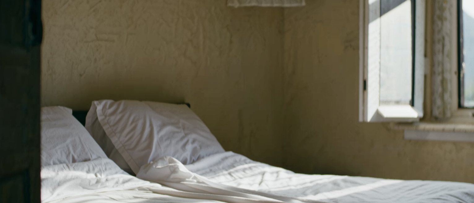 a made bed seen from the doorway with the covers turned down on both sides