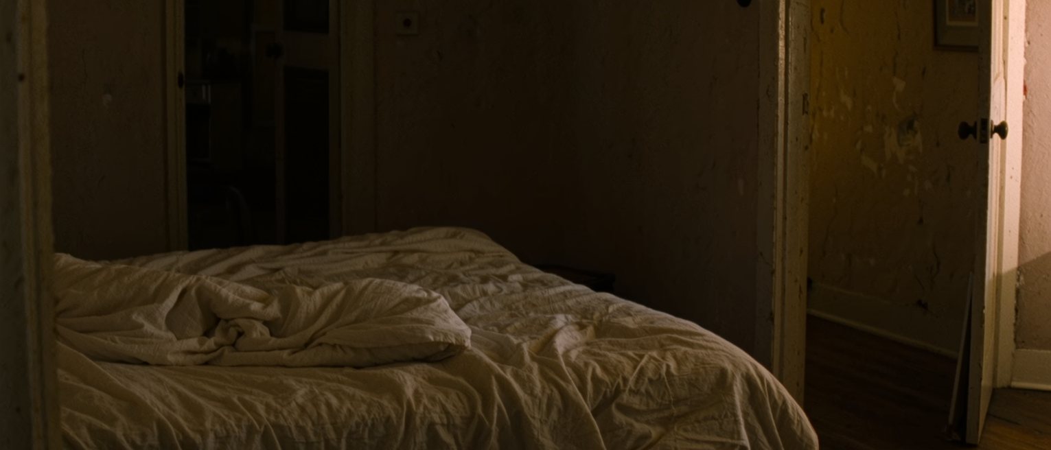 a made bed seen from the doorway with the covers turned down on both sides