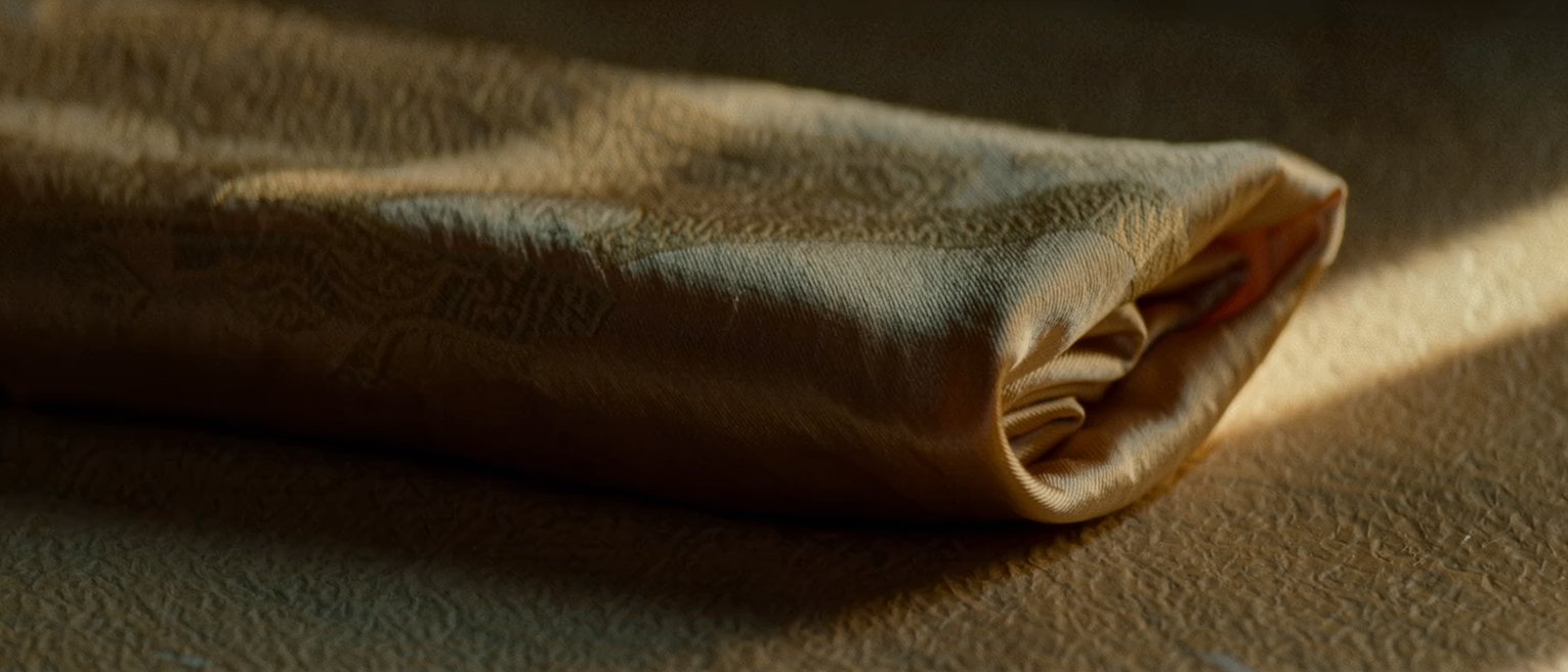 a folded silk kimono sleeve, the lining showing only at the cuff