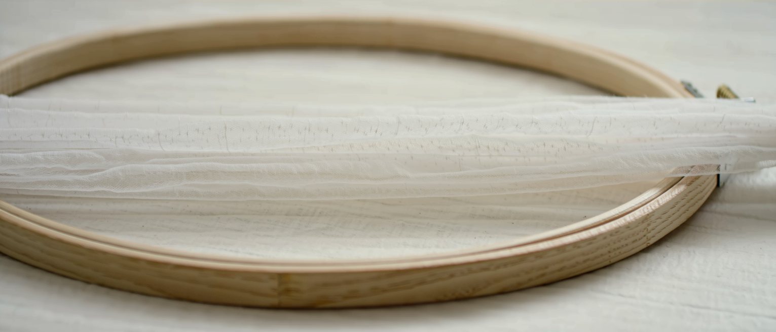 a length of plain gauze stretched taut on a wooden hoop