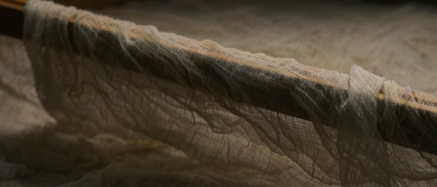 a length of plain gauze stretched taut on a wooden hoop