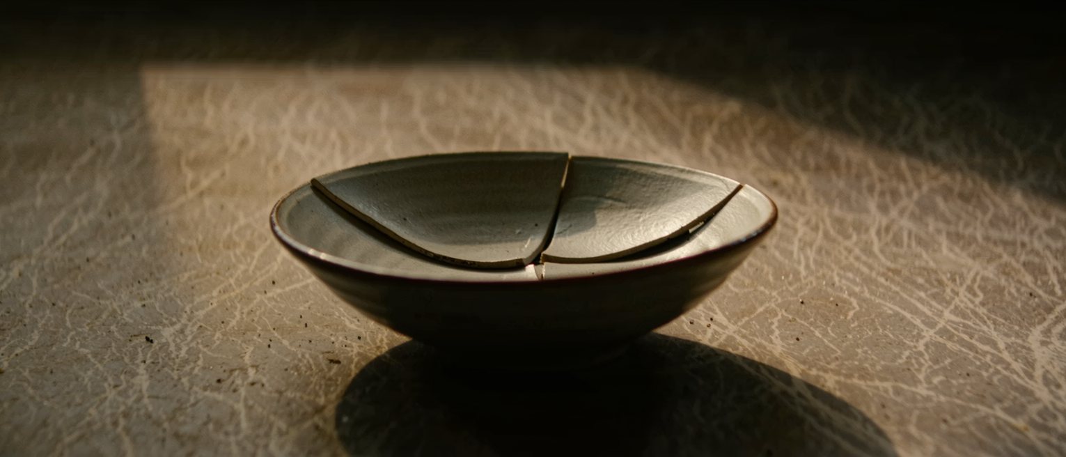 a ceramic bowl whose old break has been glued back together, the join line visible and holding with no piece missing and no gap