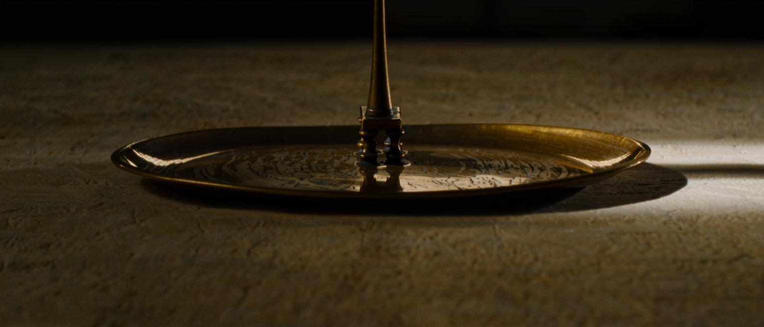 a brass scale pan hanging level and empty, the beam steady